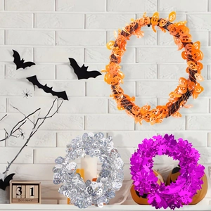 Close-up of Halloween tinsel garlands with pumpkin, skull, and purple sequin accents
