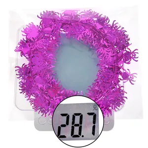 Macro detail of purple spider tinsel garland on a scale weighing 28.7g for Halloween party