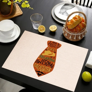 Detail of linen placemat with 'Proud Dad' tie print and decorative kitchen setting