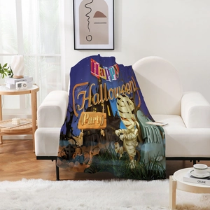 Detail einer Halloween-Flanell-Decke mit Mumien und Schlössern auf weißem Sofa