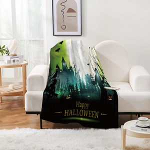 Detail einer Halloween-Kuscheldecke mit Gothic-Schloss und Kürbis auf weißem Sofa