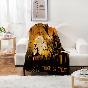 Detail einer Halloween-Flanell decke mit Kürbis- und Geistprint auf einem weißen Sofa