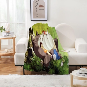 Vue détaillée d'une couverture en flanelle Totoro posée sur un canapé dans un salon