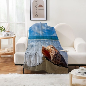 Détail d'une couverture en flanelle douce avec des vagues d'océan et un grand coquillage