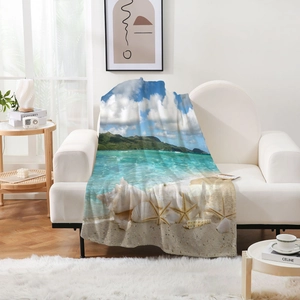 Détail de la couverture en flanelle motif océan avec coquillages et étoiles de mer
