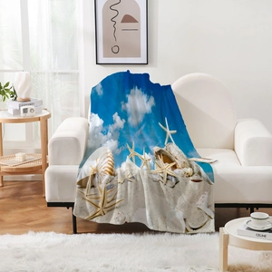 Détail d'une couverture en flanelle à motif étoile de mer sur un canapé blanc moderne