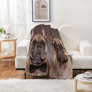 Détail d'une couverture en flanelle avec imprimé bouledogue sur un canapé blanc