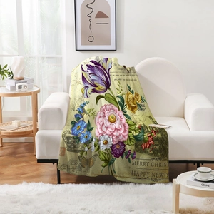 Detail of vintage floral flannel blanket featuring tulips and peonies on a white sofa