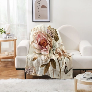 Detail of vintage floral flannel blanket featuring pink roses and butterflies on a sofa