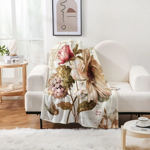Detail of vintage floral and butterfly flannel blanket draped on a cozy sofa
