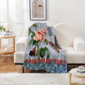 Detailed view of flannel blanket with pink roses and butterfly on a white sofa