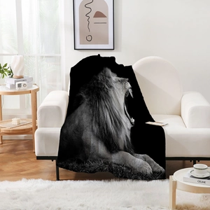 Close-up of roaring lion print on black flannel blanket draped over a white sofa