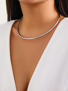 Choker minimalista in metallo argentato sul collo della modella con finitura lucida