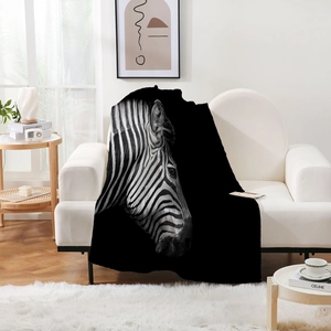 Detail of plush zebra print flannel blanket draped on white sofa in modern interior
