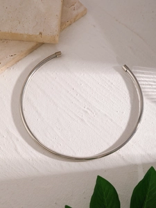 Primo piano di un choker in metallo argento con un design aperto minimalista