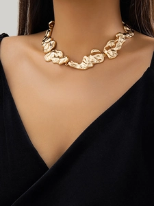 Detailed macro view of irregular lava texture and gold-plated molten design on the choker
