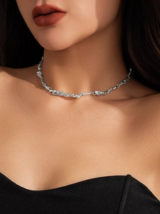 Close-up of irregular liquid metal choker necklace with flowing silver texture on neck