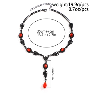 Detailed view of Gothic bat wing necklace with red oval gemstone and teardrop bead charm