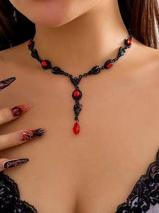 Dettaglio collana gotica con pietre rosse e motivi a pipistrello in stile dark