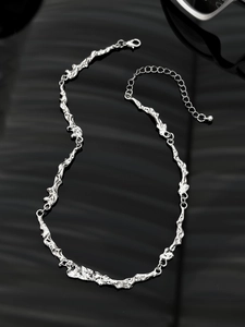 Detailed macro of irregular liquid metal texture necklace with adjustable silver clasp