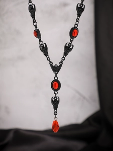 Collana gotica con pipistrello e pietre rosse e pendente a goccia su contrasto