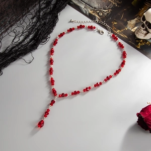 Gothic red crystal beaded Y-necklace with blood drop pendant on dark aesthetic background