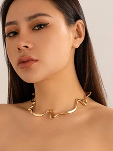 Detail shot of a liquid gold irregular wavy choker necklace with polished metal texture