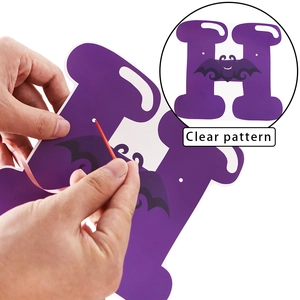 Detail of Halloween purple banner with black bat pattern showing DIY threading process