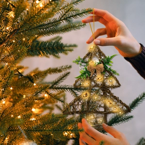 Detail view of a glowing star-shaped wood rattan Christmas ornament with LED warm lights