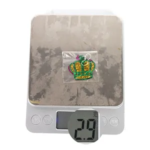 Detail shot of Mardi Gras crown earrings on a digital scale showing 2.9g weight