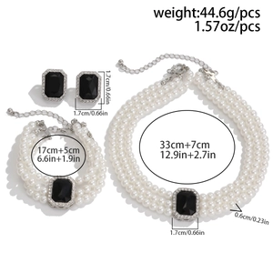 Détail d'un ensemble de bijoux en perles à plusieurs rangs avec pierres noires rectangulaires