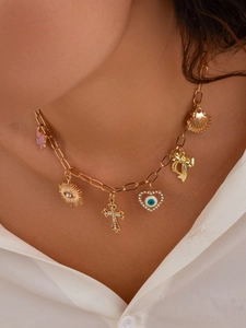 Detailaufnahme der goldenen Büroklammerkette mit Muschel, Kreuz und Schmetterling Anhänger