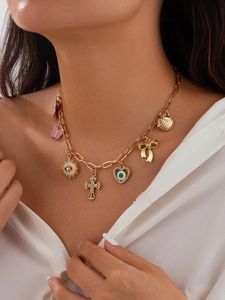 Detail der vergoldeten Kette mit bunten Muschel- und Kreuzanhängern am Modell