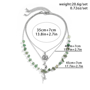 Detailed view of triple-layer necklace with green stone, sun and moon pendants