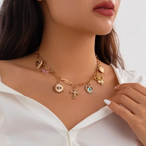 Goldene Bettelkette mit Herz-, Schmetterlings- und Evil Eye-Anhängern am Modell