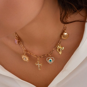 Goldene Halskette mit Muschel, Kreuz und Evil-Eye-Anhänger am Modell getragen