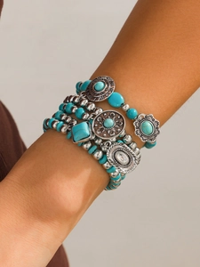 Detail of bohemian multilayer turquoise bead bracelet set with vintage silver charms