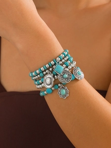 Detail view of Bohemian multi-layer turquoise beaded bracelets with vintage silver charms