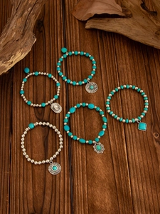Detail of bohemian turquoise beaded bracelet set with vintage silver metal charms