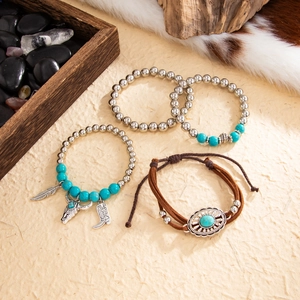 Bohemian turquoise bead bracelet set with silver charms and cowhead pendant on textured base