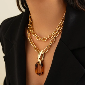 Collier double chaîne dorée avec fermoir à bascule et pendentif ovale en résine ambre
