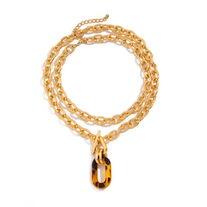 Collier à chaînes dorées avec pendentif ovale en acrylique ambré et fermoir à bascule