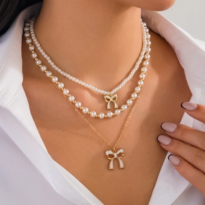 Set di collane di perle a tre strati con eleganti ciondoli a fiocco in smalto bianco