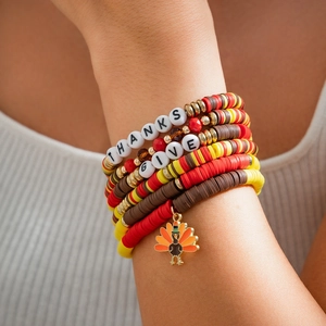 Detail eines Thanksgiving-Armbands mit Tonperlen und Truthahn-Anhänger am Handgelenk