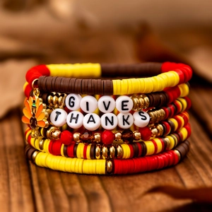 Makroansicht der Erntedankfest-Armbänder mit Truthahn-Anhänger und GIVE THANKS Perlen