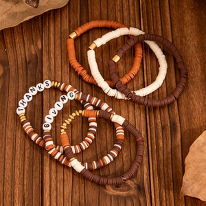 Close-up of Thanksgiving beaded bracelet set with clay beads and maple leaf charms