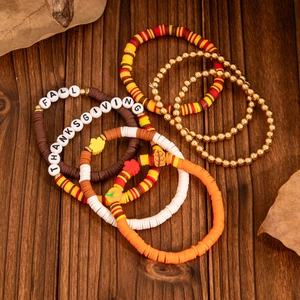 Macro shot of 5-piece Thanksgiving clay bracelets with Fall letters and pumpkin charms