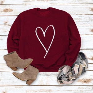 Flat lay of a red long-sleeve sweatshirt with white heart print and plaid scarf