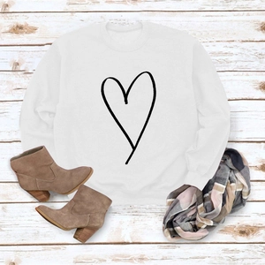 Flat lay of white crewneck sweatshirt with heart print, styled with boots and scarf