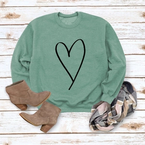 Sage green sweatshirt with black heart outline on rustic white wooden background